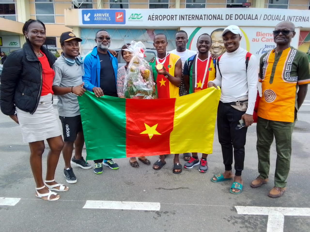 Douala, le 10 août 2023. Alex Fotso Djitouo, médaille d'or au cou, accueilli à l'aéroport international de Douala par ses encadreurs et connaissances